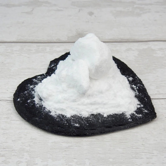 Alpha Arbutin Powder on a heart shaped black slate 