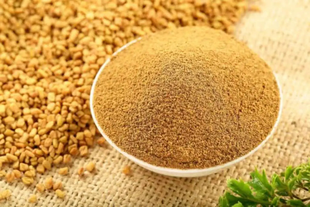 Fenugreek powder in a white bowl on a woven raffia surface with fenugreek seeds 