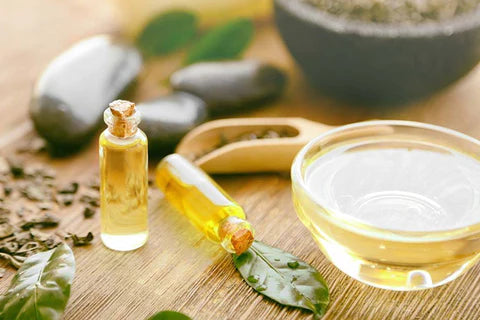 Vitamin e oil in 2 transparent glass bottles with a cork lid , a glass bowl of vitamin E oil on a wooden table